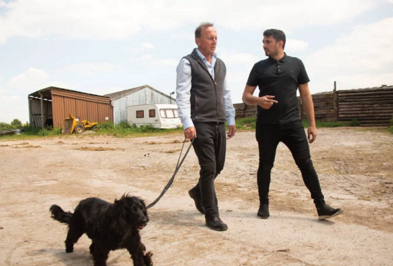 two men walking with a dog