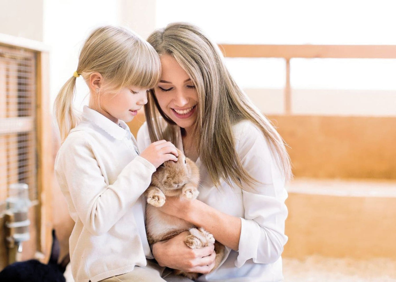 mom and daugther petting a bunny