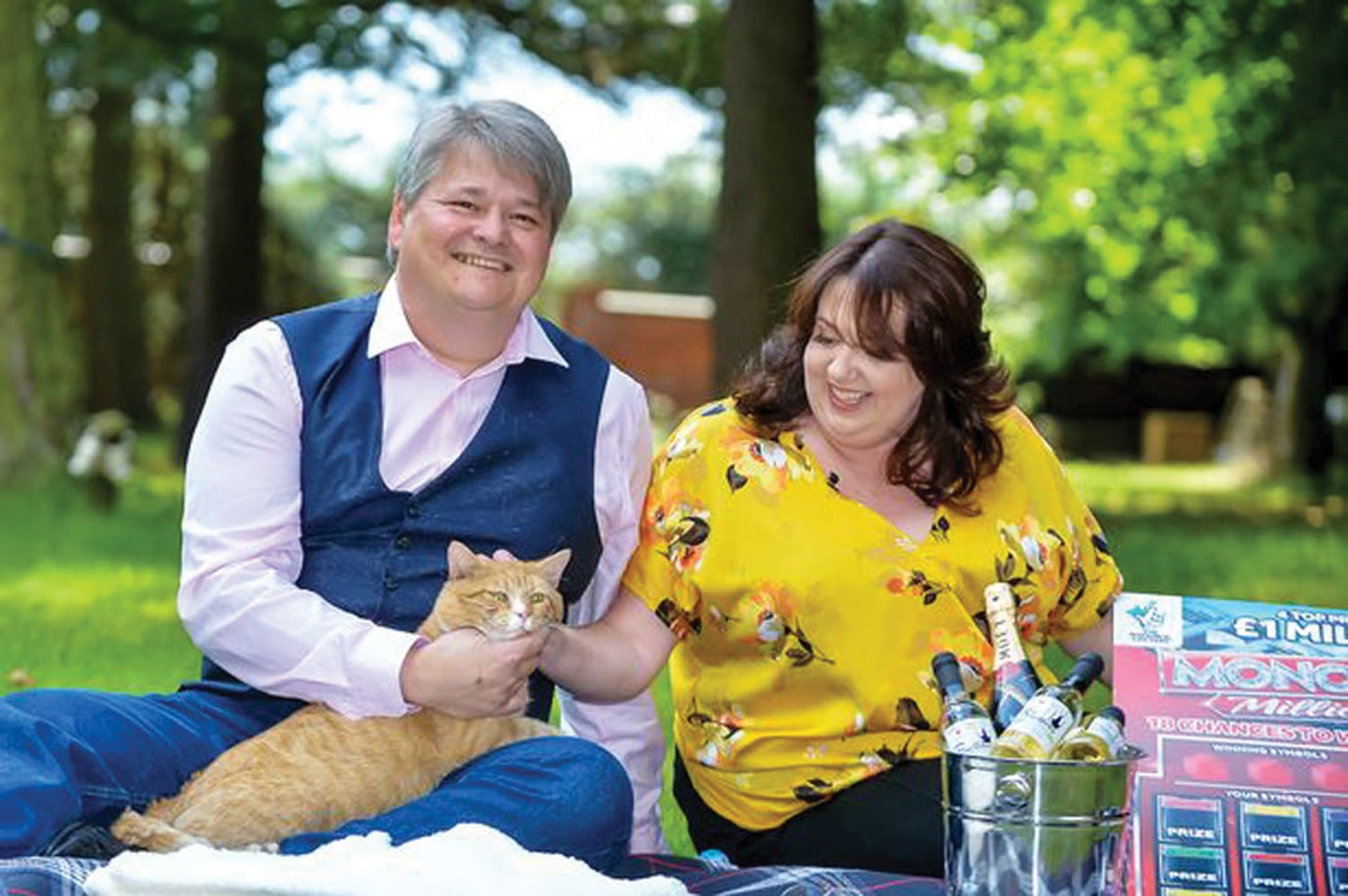 lucky cat with two pet owners picknick setting in the park